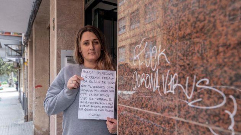 Mirian Armero, cajera de un supermercado de Cartagena, muestra en el portal del edificio donde vive, la carta que un vecino metida por debajo de su puerta y que encontró su hijo de 10 años, en la que le recomiendan que se busque otra vivienda mientras dur