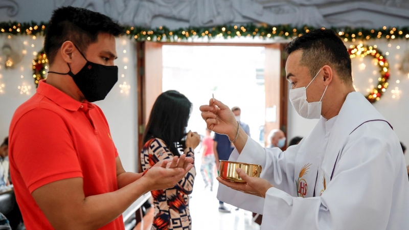 Bangkok (Tailandia), 25/12/2020.- Personas con máscaras protectoras hacen cola para recibir la Sagrada Comunión en sus manos durante una misa del día de Navidad en una iglesia en Bangkok, Tailandia, el 25 de diciembre de 2020. Aunque Tailandia es un país