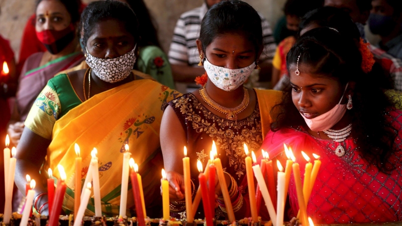 Indian Christians light candles after attending the Christmas prayers at the Infant Jesus church in Bangalore, India, 25 December 2020. Most Christians celebrate Christmas on 25 December to commemorate the birth of Jesus, the central figure of Christianit