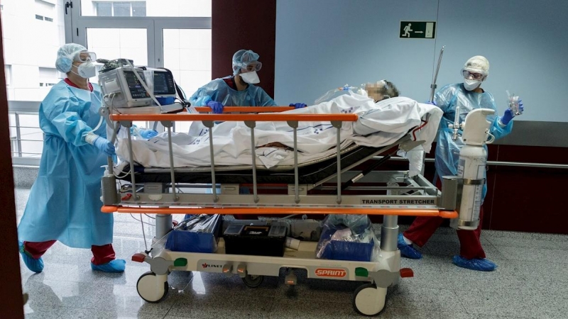 23/12/2020. Profesionales sanitarios trasladan a una persona enferma por covid-19. - EFE
