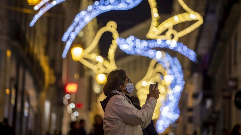 Una mujer bajo la iluminación navideña.