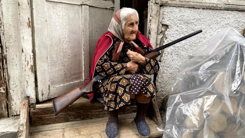 Una anciana con su escopeta en la puerta de su casa en Stepanakert, la capital del enclave separatista de Nagorno Karabaj disputada por Azerbaiyán y Armenia, que ha vuelto a ser atacada hoy domingo con cohetes. El ejército terrorista azerbaiyano sigue ata