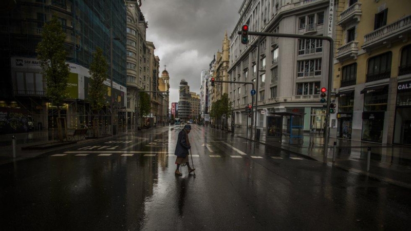 La expansión del virus por España y la declaración del estado de alarma el 14 de marzo dejaron un panorama nunca visto: ciudades casi sin gente ni actividad. En la imagen, una mujer cruza un paso de peatones en la Gran Vía de Madrid, el pasado 23 de marzo