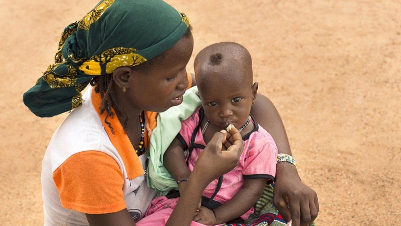 Una madre da de comer a su hijo desnutrido en Burkina Faso.