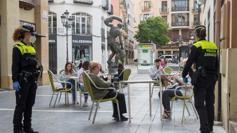 Una patrulla de la Policía Local mide las distancias de las mesas de una terraza en el casco viejo de Zaragoza.