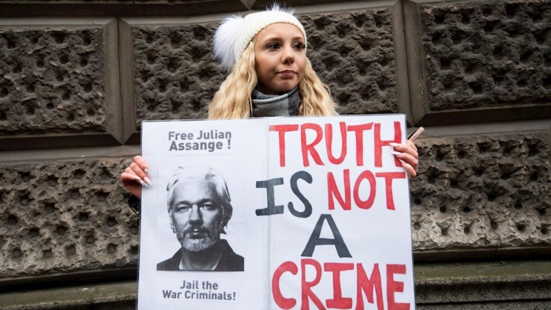 Una mujer con una pancarta de apoyo a Julian Assange frente a la corte penal londinense de Old Bailey.