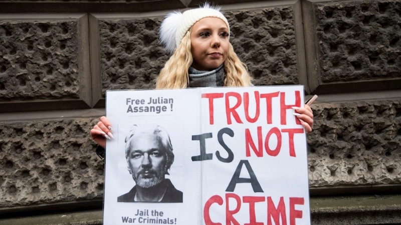 Una mujer con una pancarta de apoyo a Julian Assange frente a la corte penal londinense de Old Bailey.