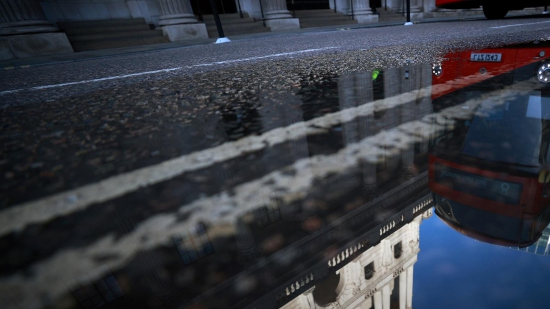 Un autobús en el centro de Londres se refleja en un charco