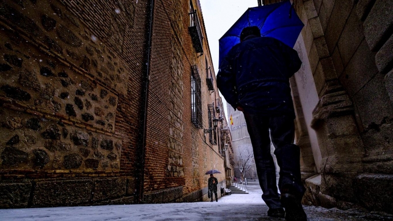 Dos ciudadanos pasean durante una nevada este jueves en Toledo. La borrasca Filomena dejará este jueves copiosas nevadas en zonas del centro y este peninsular, con cotas bastante bajas y espesores de más de 10 centímetros en el este de Castilla-La Mancha,