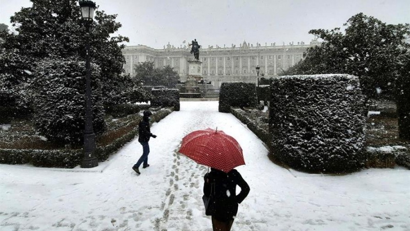 Personas disfrutan de la nieve este viernes en la Plaza de Oriente de Madrid. La Agencia Estatal de Meteorología (Aemet) ha activado el nivel rojo por la previsión de fuertes nevadas hoy viernes por la tarde en varias zonas de las comunidades de Madrid, e