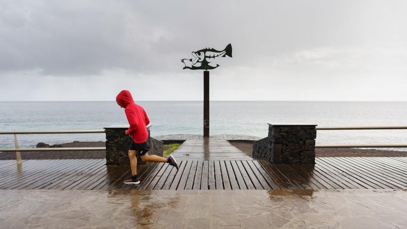 Un corredor practica deporte en la costa de Las Caletillas, en el municipio de Candelaria (Tenerife). Todas las Islas Canarias se encuentran este viernes en aviso naranja o amarillo por las condiciones meteorológicas de la borrasca Filomena.