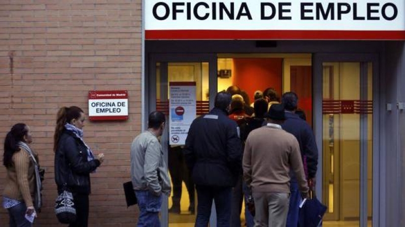 Varias personas hacen cola para entrar en una oficina de empleo en Madrid.