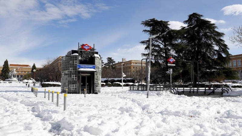 Vista de la salida de metro de Ciudad Universitaria cubierta de nieve este lunes. La Comunidad de Madrid se abre paso poco a poco tras el paso del temporal Filomena con la mayor parte de las calles y carreteras aún blancas y con hielo, sin autobuses, sin