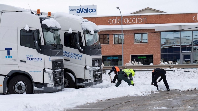 Miembros de la Guardia Civil y Protección Civil ayudan a desatascar los camiones embolsados en el polígono La Paz de Teruel. A partir de esta madrugada se espera la llegada de una ola de frío, con un acusado descenso de las temperaturas a partir del lunes