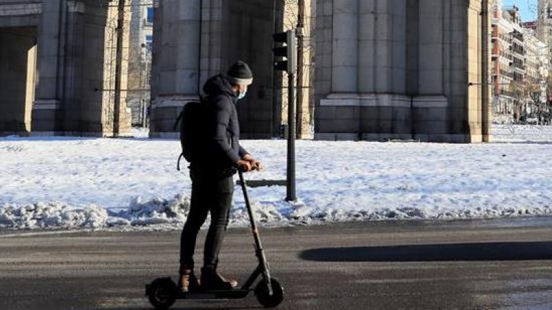 Un hombre circula con su patinete eléctrico por la madrileña calle Alcalá tras el paso de la borrasca Filomena.