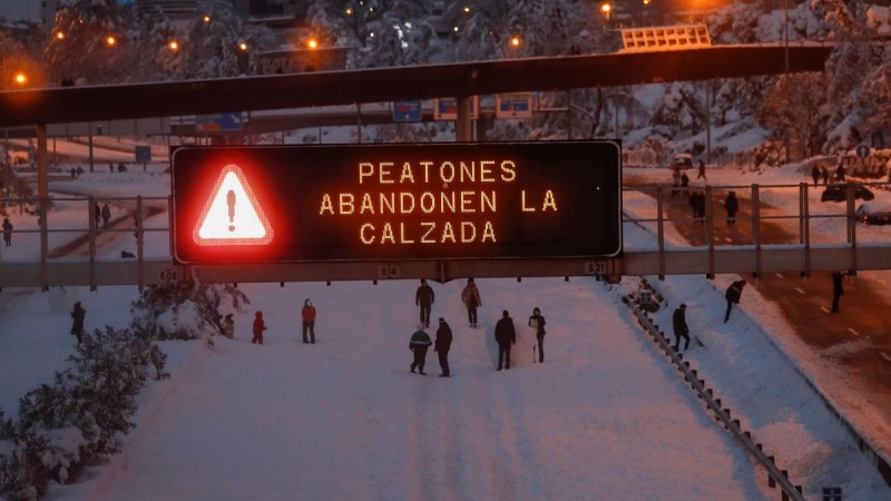 Varios ciudadanos caminan y juegan con la nieve en mitad de la M-30 de Madrid.