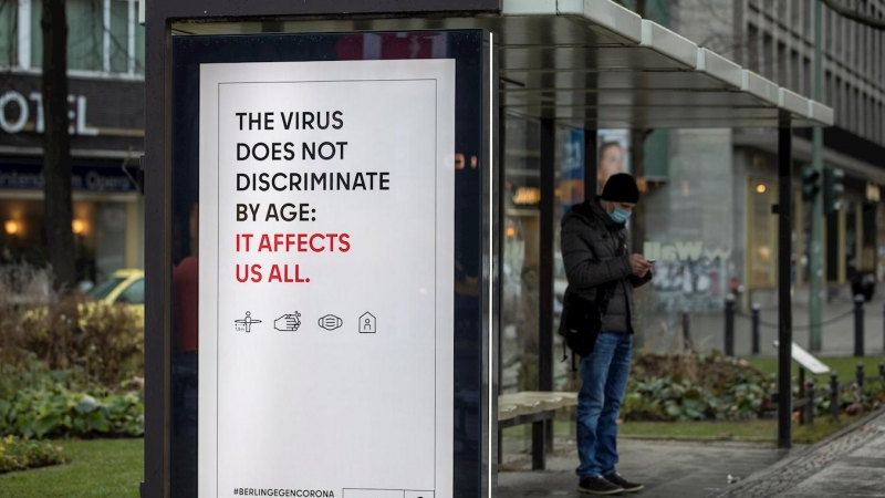 Un cartel advierte del riesgo de contagio de la covid-19 para cualquier edad, en una parada de autobús en Berlin.