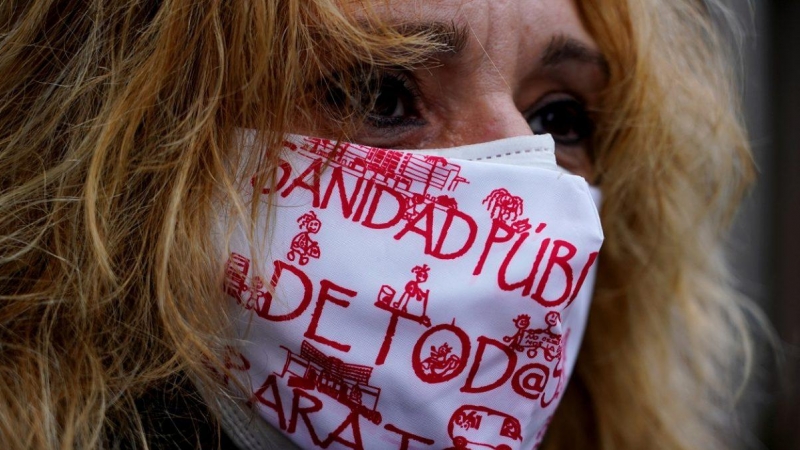 Una mujer con mascarilla, con lemas a favor de la sanidad pública, en una manifestación en Madrid.