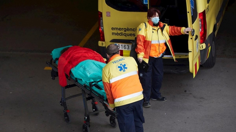 Dos técnicos de ambulancias trasladan a un paciente en el Hospital del Mar de Barcelona, coronavirus