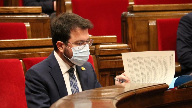 El vicepresident amb funcions de president, Pere Aragonès, durant la sessió de la Diputació Permanent del Parlament d'aquest dimecres revisant documentació al seu escó.