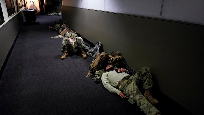 Miembros de la Guardia Nacional duermen en los pasillos de las oficinas del Capitolio.