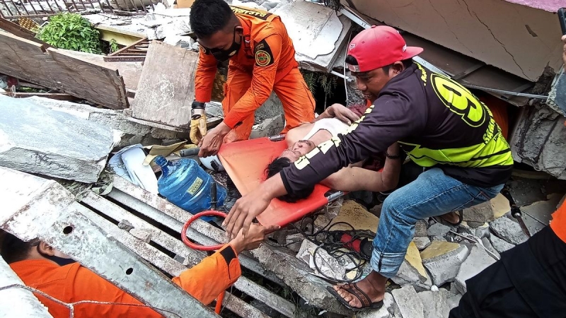 Los servicios de emergencia rescatan a un hombre de las ruinas de un hospital en Mamuju.