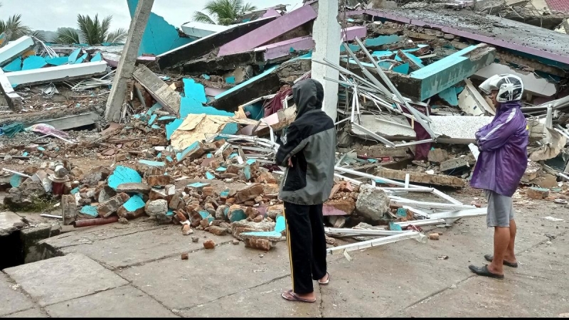 Ciudadanos de la ciudad de Mamuju observan las ruinas de uno de los hospitales afectados por el terremoto.