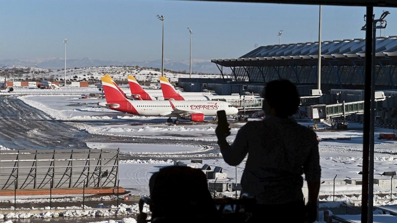 11/01/2021.- Una pasajera toma fotos de las pistas en la Terminal 4 del aeropuerto Adolfo Suárez Madrid-Barajas.