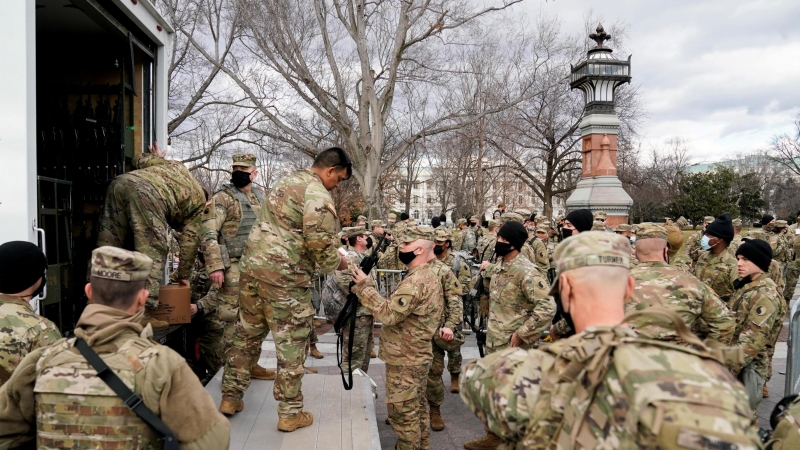 Las tropas de la Guardia Nacional reciben armas y municiones fuera del edificio del Capitolio de los Estados Unidos mientras se espera que los partidarios del presidente de los Estados Unidos, Donald Trump, protesten contra la elección del presidente elec