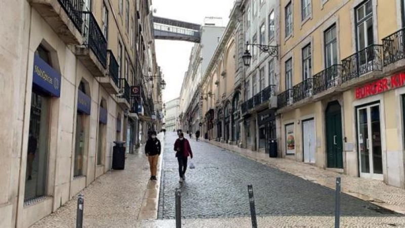 os personas caminan este miércoles por una calle vacía del centro de Lisboa (Portugal).