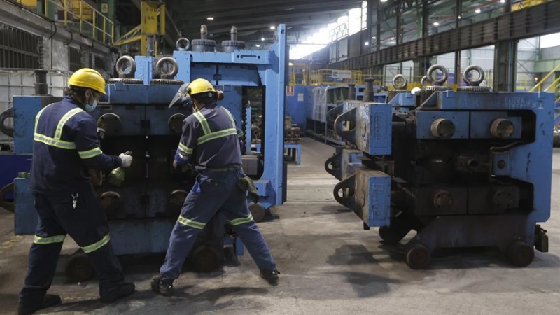 Dos trabajadores ante una máquina en las instalaciones de Sidenor.
