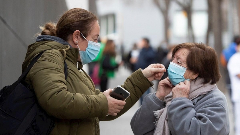 Una mujer ayuda a otra a colocarse la mascarilla este martes en Barcelona.