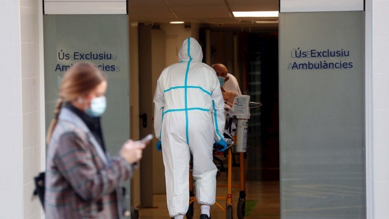 Un sanitario traslada a un enfermo en el Hospital Clínico de València.