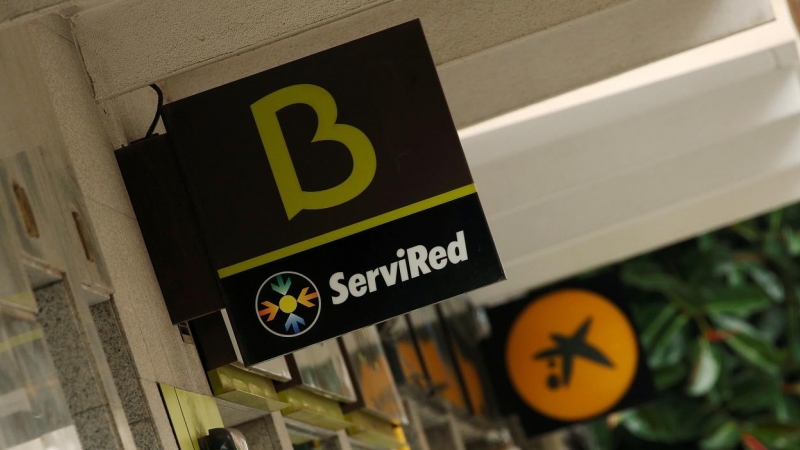 Los logos de Bankia y de Caixabank en sendas sucursales en Barcelona. REUTERS/Albert Gea