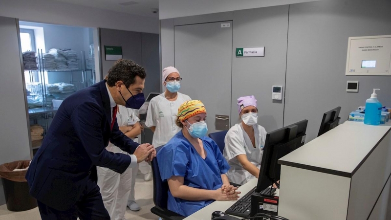 El presidente de la Junta, Juanma Moreno, junto al personal sanitario del nuevo Hospital de Emergencia Covid-19, construido en el antiguo Hospital Militar Vigil de Quiñones en Sevilla, que ha entrado hoy en funcionamiento.