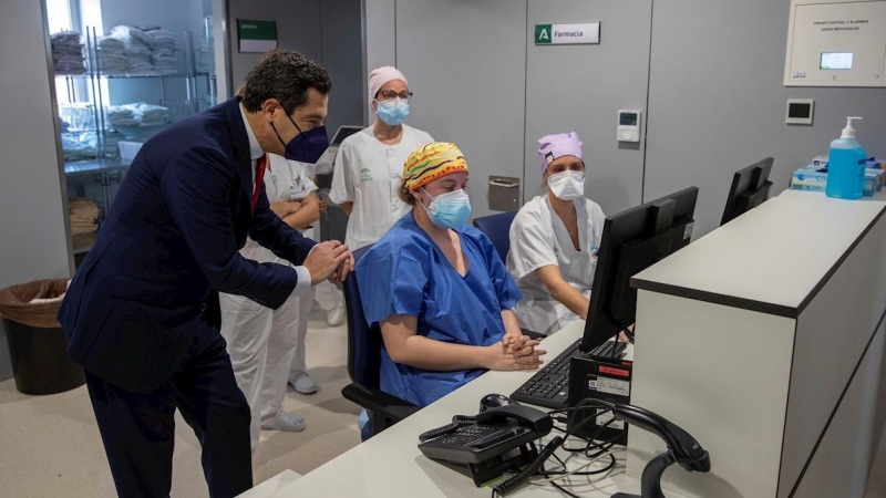 El presidente de la Junta, Juanma Moreno, junto al personal sanitario del nuevo Hospital de Emergencia Covid-19, construido en el antiguo Hospital Militar Vigil de Quiñones en Sevilla, que ha entrado hoy en funcionamiento.