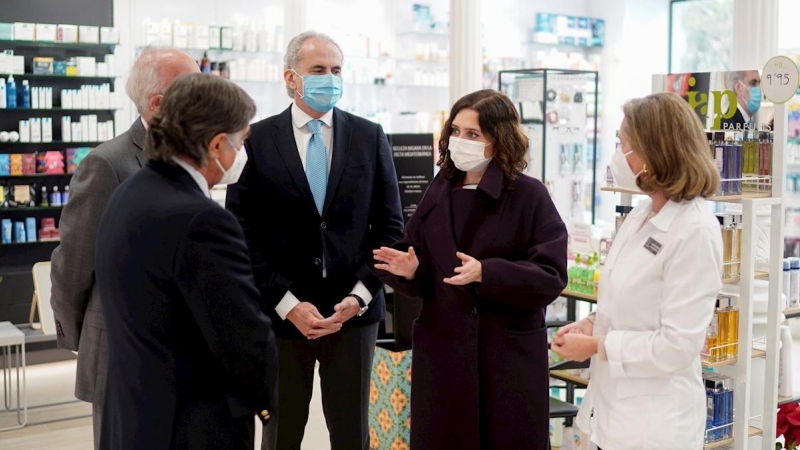 Fotografía facilitada por la Comunidad de Madrid de la presidenta regional, Isabel Díaz Ayuso, y el consejero de Sanidad, Enrique Ruz Escudero, en su visita este martes a una de las farmacias situada en Centro de Madrid donde los ciudadanos pertenecientes