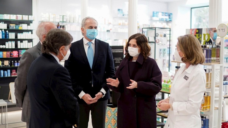 Fotografía facilitada por la Comunidad de Madrid de la presidenta regional, Isabel Díaz Ayuso, y el consejero de Sanidad, Enrique Ruz Escudero, en su visita este martes a una de las farmacias situada en Centro de Madrid donde los ciudadanos pertenecientes