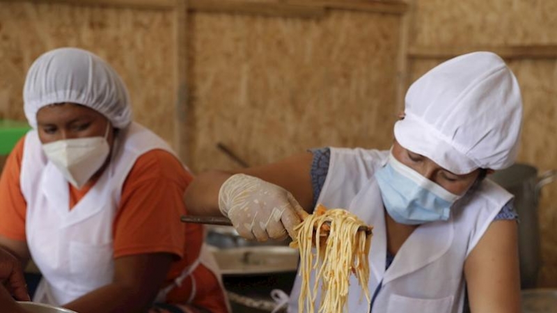 Unas mujeres preparan alimentos en el asentamiento humano de Buena Vista el 2 de febrero de 2021, en el populoso distrito limeño de Villa María del Triunfo, en Lima (Perú).