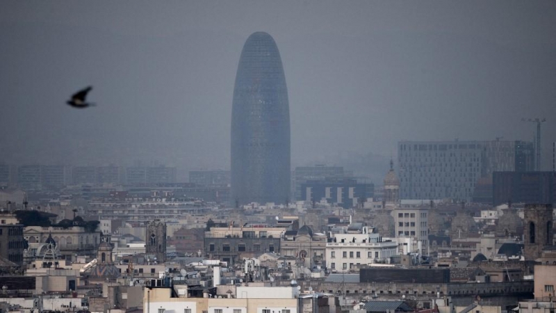 La torre Glòries de Barcelona tras una nube densa de contaminación.