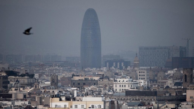 La torre Glòries de Barcelona tras una nube densa de contaminación.