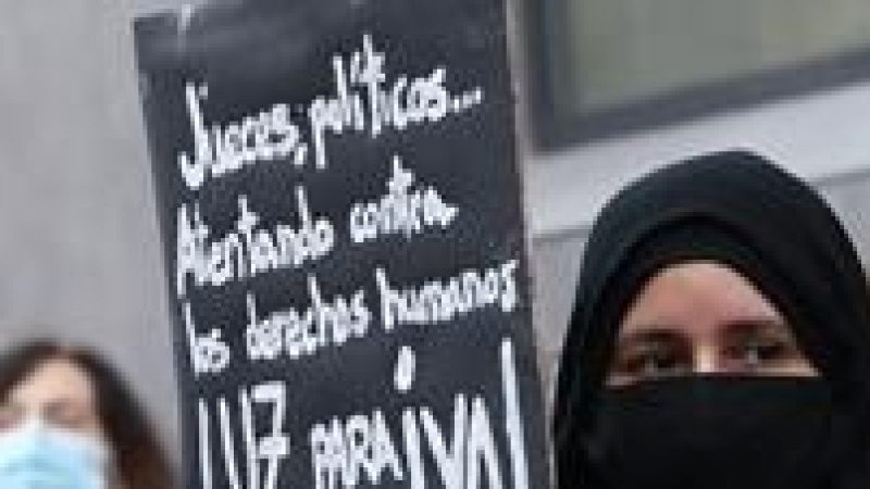 Una mujer sostiene una pancarta donde se lee 'Luz para Cañada Real ¡YA!!' durante una manifestación de vecinos de los sectores V y VI de la Cañada Real Galiana frente a la Asamblea de Madrid (España), a 4 de febrero.