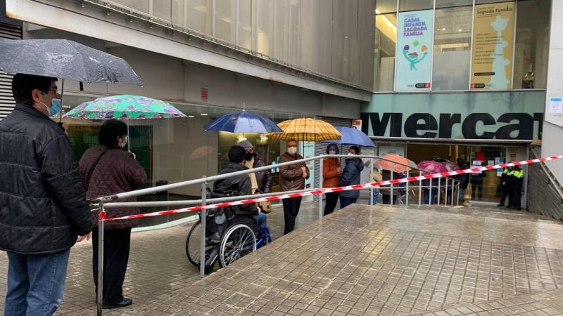 Votants fent cua per votar al mercat de la Sagrada Família.