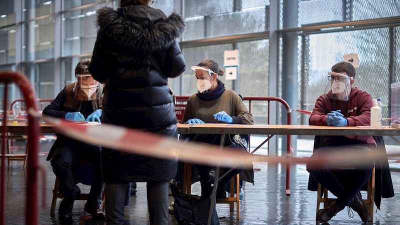 14/02/2021.- Una mujer ejerce su derecho al voto para las elecciones al Parlament, hoy en el polideportivo de Fontajau, de Girona.La participación en las elecciones al Parlament de Cataluña a las 13.00 horas se sitúa en el 22,77 por ciento del censo, casi