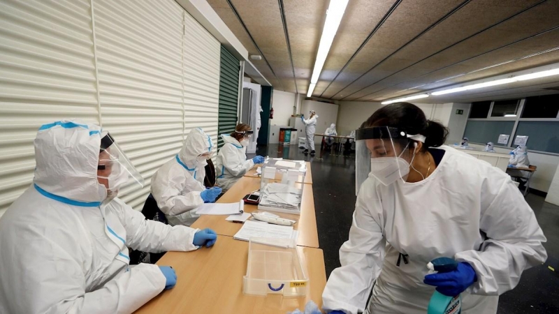 Una operaria desinfecta una mesa tras votar un ciudadano en la Escuela Fort Pienc de Barcelona el domingo durante las elecciones.