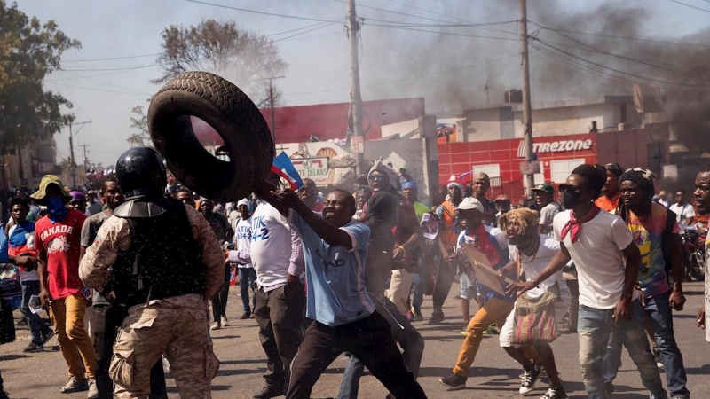 Grupos de personas se enfrentan a la policía durante una jornada de protesta contra el Gobierno de Jovenel Moise hoy, en Puerto Príncipe (Haití).
