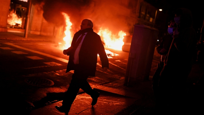 Un hombre corre durante una protesta en apoyo del cantante de rap catalán Pablo Hasel