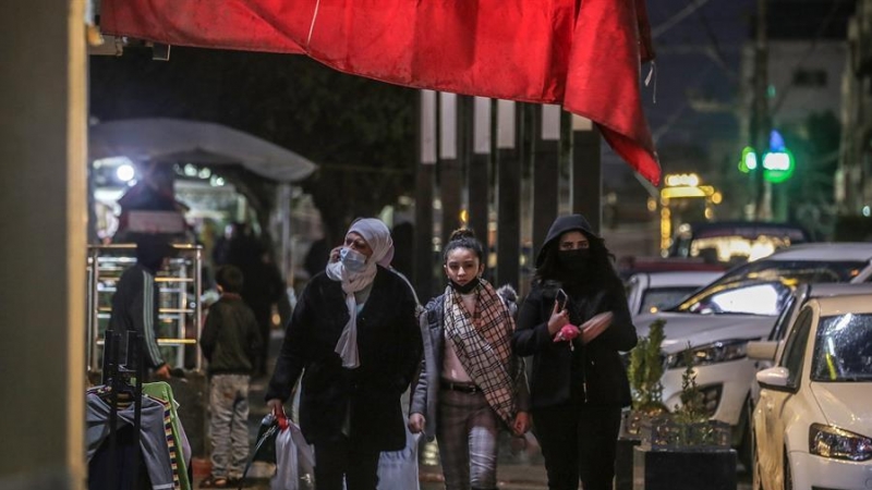 Mujeres palestinas pasen con mascarillas por las calles de Gaza.