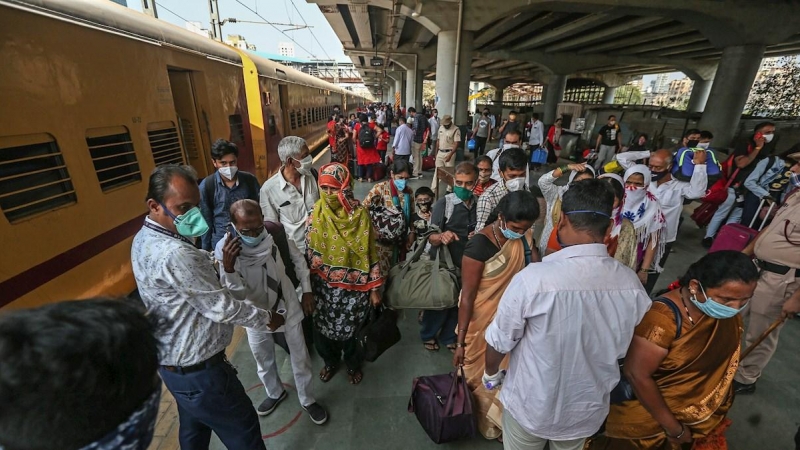 Personal sanitario hace controles de temperatura a viajeros en una estación de trenes en Bombay (India).