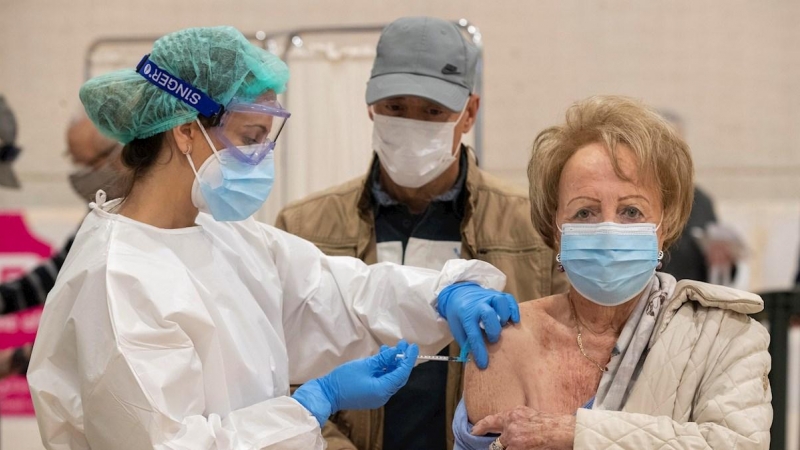 Una sanitaria de la Consejería de salud de la Comunidad de Murcia administra la vacuna Moderna contra la covid-19 a una mujer mayor de 80 años.